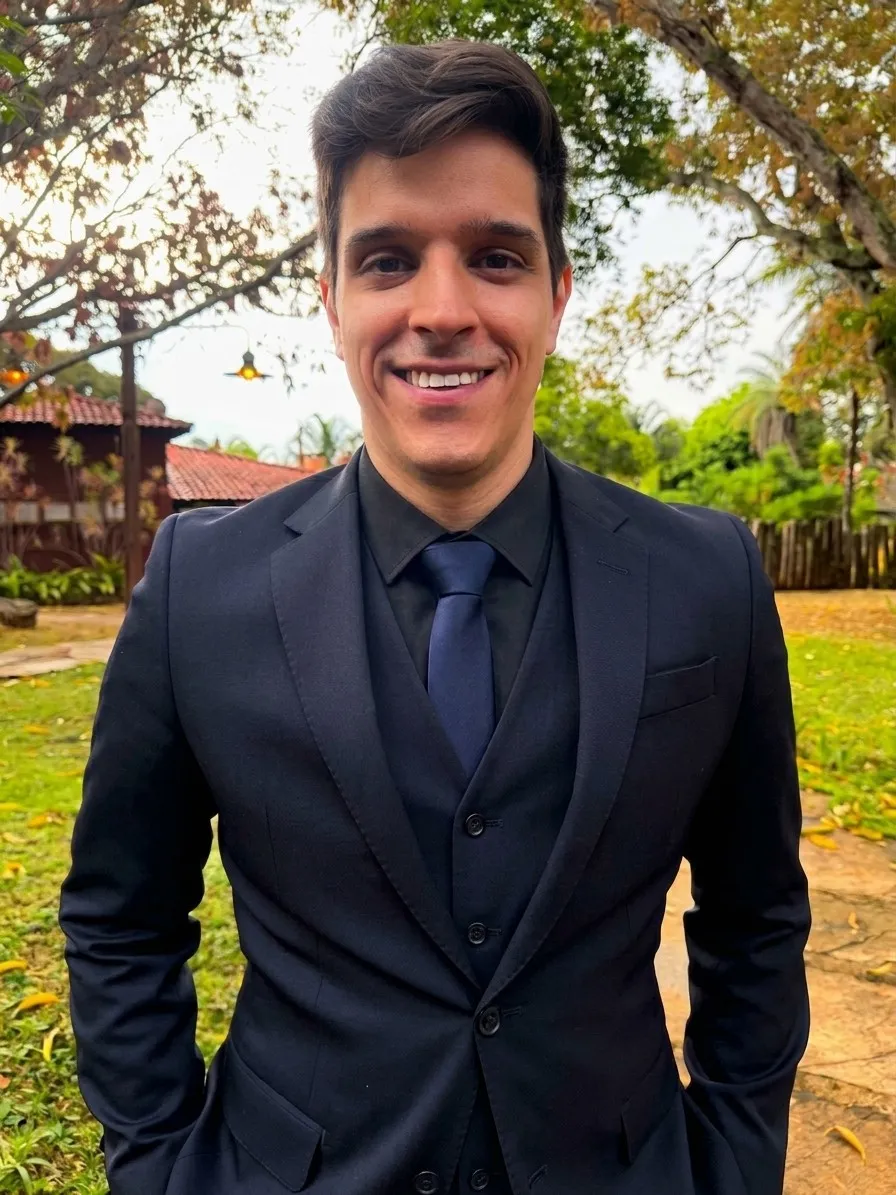 Vinicius Vieira, smiling, wearing a dark suit outdoors